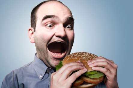 guy eating bi hamburger with bun